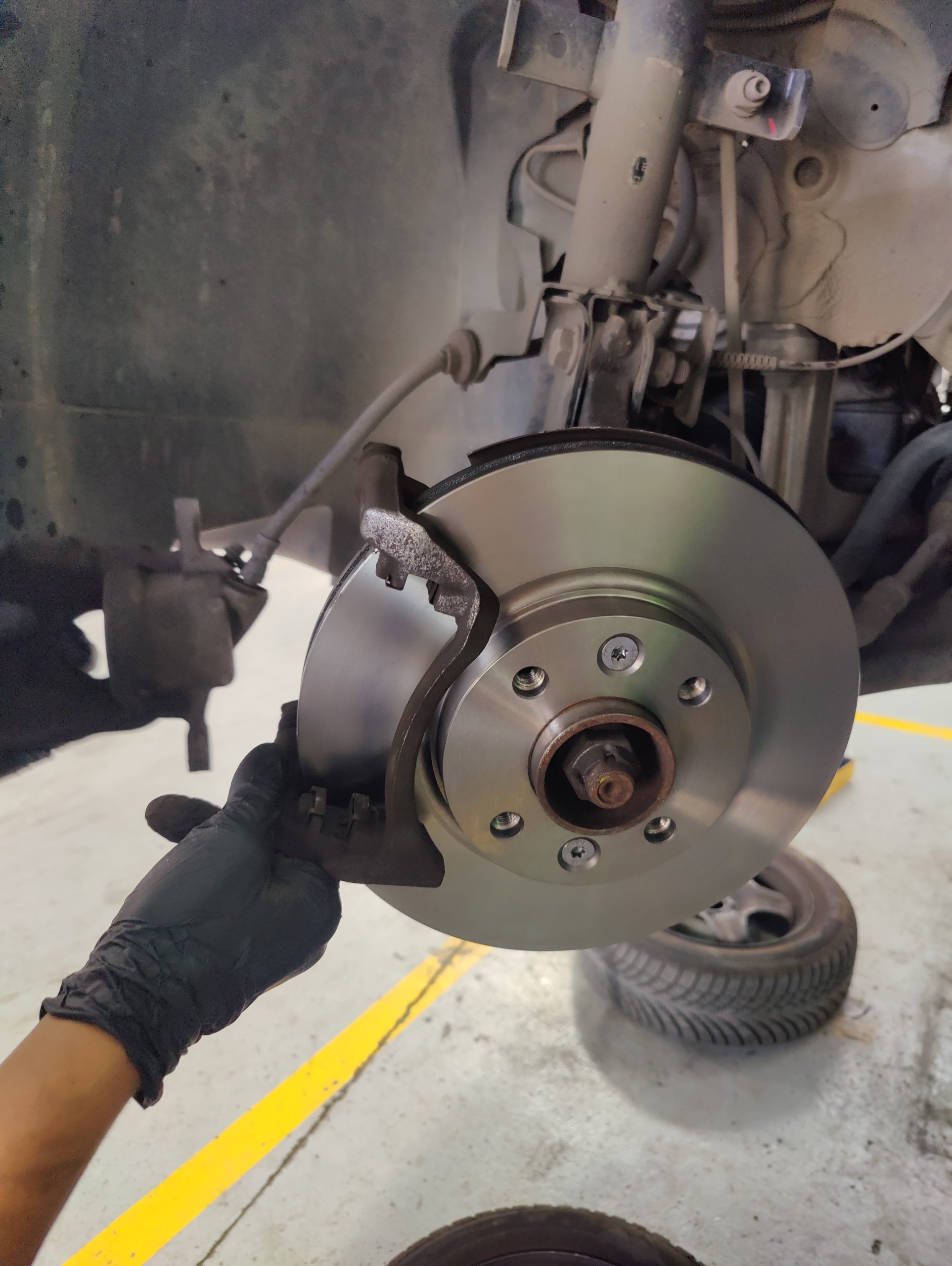 Mirsan Otomotiv Bosch Car Service atölyesinde, deneyimli teknisyenin modern beyaz bir VW Golf üzerinde hassas fren tork ayarı yapması